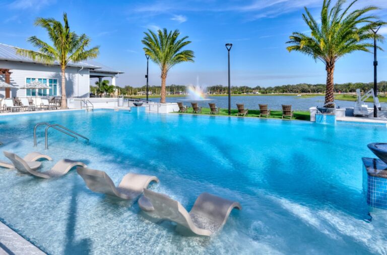 luxury pool by lake and palm trees